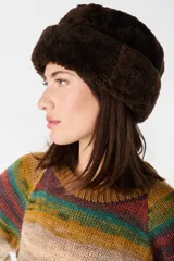 Gorro tipo bucket de cuero napalan con interior de pelo sintético tipo corderito, en color marrón chocolate. Presenta una forma redonda con botamanga ajustable.