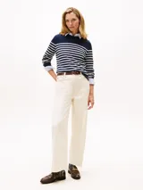 Sweater de punto fino en algodón, con diseño de rayas horizontales en azul marino y blanco. Presenta cuello redondo, mangas largas con puños acanalados y detalle de botones dorados en uno de los hombros.