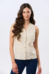 Musculosa de lino color beige, con cuello mao y escote en V, cierre frontal con botones y dos bolsillos plaqué con solapa en el pecho.