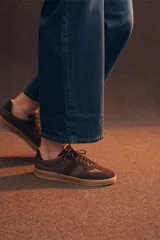 Zapatilla urbana de cuero vacuno y gamuza en color suela, con cordones al tono y suela de caucho. Diseño clásico con paneles combinados.