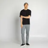 Pantalón chino de hombre, color gris verdoso, corte slim y tiro medio. Presenta cinco bolsillos y puños doblados.