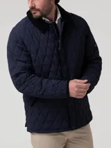 Campera acolchada azul marino con costuras en rombos, cuello de pana negro y cierre frontal con botones a presión. Incluye bolsillos laterales con ribete de pana y broches ajustables en la cintura.