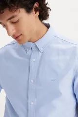 Camisa celeste de manga corta con cuello abotonado y logo bordado en el pecho.