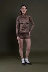 Short de lycra color marrón con estampado de letras y figuras geométricas en tonos más oscuros.