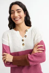 Sweater de tejido de punto con franjas horizontales en color blanco, verde claro y verde oscuro. Tiene cuello en V con botones.