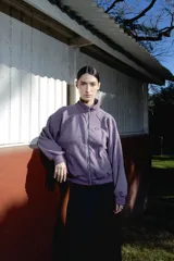 Campera negra de cuello alto con cierre frontal metálico completo, bolsillos laterales y logo bordado en el pecho.