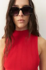 Musculosa negra de tejido de punto acanalado, con cuello alto y corte ajustado.