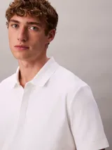 Chomba de manga corta Calvin Klein confeccionada en algodón interlock, con cuello clásico y cierre frontal de botones.