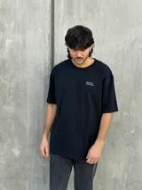 Remera negra oversize con estampado geométrico en la espalda y logo 'Osten' en la parte inferior.