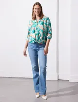 Blusa estampada de seda fría marca Figueroa & Flower. Tiene cuello a la base y escote en V, detalle de diferente estampa en hombros y espalda, apertura central con botones de nácar, mangas 3/4 regulables con presilla y botón, y terminación de ruedo con nudo.