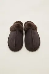 Pantuflas cerradas color marrón con ribetes de piel sintética en la abertura y suela plana.