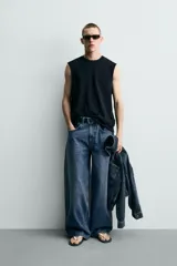 Camiseta tank de punto de algodón, color negro, de corte relaxed fit con cuello redondo, manga sisa y acabados irregulares.
