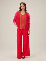 Saco abierto de tejido de punto con diseño de bloques de color. Presenta cuerpo en rojo con solapas en tono tostado y mangas largas en color fucsia con textura acanalada.