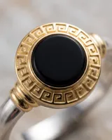 Anillo de plata 925 con diseño redondo, piedra ónix central y detalle de lámina de oro de 18k con guarda griega alrededor.