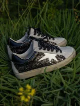 Championes urbanos Champion modelo Gian, color gris con detalles en negro y blanco, con apliques de glitter negro en los laterales y estrella blanca.