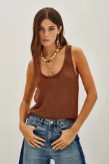 Top de punto color beige, con escote en U pronunciado y textura sedosa y brillante.