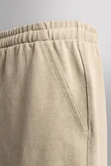 Short jogger marrón de corte relaxed fit, confeccionado en tejido compacto de algodón, con cintura elástica ajustable, bolsillos frontales en la cadera y bolsillo trasero de plastrón.