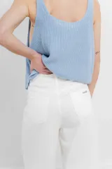 Chaleco celeste de punto con escote en V y cierre frontal con botones. Tejido calado y corte holgado.