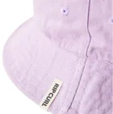 Sombrero tipo bucket reversible de Rip Curl. Un lado presenta un estampado geométrico en tonos marrón, amarillo y lavanda. El reverso es de color lila liso.