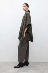 Capa negra con solapa y cuello tejido, de corte amplio y sin mangas.