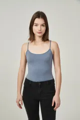 Musculosa ajustada al cuerpo color blanco hueso, con breteles finos y escote redondo.