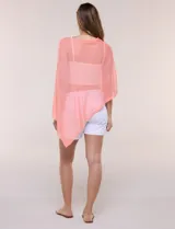 Poncho liviano de tejido de punto fino calado, color blanco, con silueta asimétrica envolvente, escote bote drapeado y mangas integradas estilo capa.