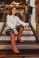 Bota alta de cuero marrón, con suela de goma y detalle de tira con hebilla en la parte superior de la caña.