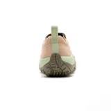 Slip on Merrell modelo Jungle Moc, confeccionado en gamuza color beige con detalles en verde claro y suela de goma marrón. Presenta diseño sin cordones con paneles elásticos laterales y tecnología Air Cushion en el talón para mayor estabilidad.
