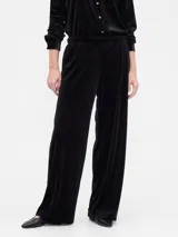 Pantalón de tiro medio y corte recto, confeccionado en terciopelo negro con cintura elástica y bolsillos laterales.