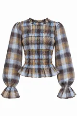 Blusa a cuadros en tonos celeste, marrón y tostado, de manga larga abullonada con puños elastizados con volados y cuerpo con detalle fruncido elástico.