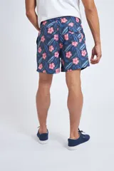 Short de baño con cintura elástica y cordón ajustable, confeccionado en tela ligera de secado rápido. Presenta un estampado botánico integral en tonos amarillos, blancos y azules, con dos bolsillos delanteros y uno posterior.