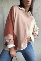 Sweater de punto con diseño color block en tonos tierra, cuello redondo y mangas largas con puños acanalados.