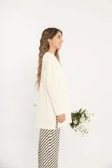 Remerón oversize de manga larga color crudo, con cuello redondo y aberturas laterales. Tejido de punto acanalado. Talle único.