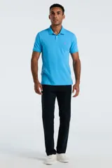 Chomba de piqué color celeste, con cuello clásico, cierre frontal de dos botones y logo bordado en el pecho.