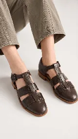 Sandalias tipo cangrejera de cuero color marrón, con diseño de tiras cruzadas y textura en la parte frontal. Cuentan con pulsera al tobillo con hebilla metálica y taco bajo.