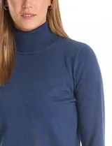 Polera de tejido fino, color rosado, con cuello alto, manga larga y detalle de tajo en los puños.