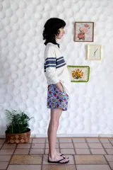 Short unisex de corte holgado con cintura elástica y estampado a cuadros rojos y blancos con dibujos de frutas.