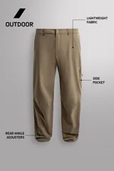 Pantalón técnico de corte regular fit en color marrón, confeccionado en tejido elástico y compacto. Cuenta con cintura ajustable con cordón interior, bolsillos frontales, bolsillo trasero con cierre oculto y bolsillo lateral con cierre en la pernera. El bajo es ajustable mediante botones a presión.
