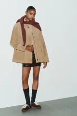 Chaqueta de ante color tostado con cuello solapa, manga larga con puño, bolsillos con solapa en el delantero y cierre frontal con botones.