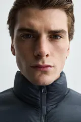 Chaleco acolchado de hombre color negro, con diseño puffer, cuello alto y cierre frontal con cremallera.