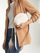 Cartera tipo bandolera de eco cuero con silueta de media luna, color beige y detalles en marrón claro. Incluye un monedero/tarjetero independiente en el bolsillo frontal y una cadena decorativa de eslabones dorados.