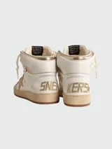 Botines de caña alta color blanco con detalles en dorado, cordones color crema y suela color caramelo.