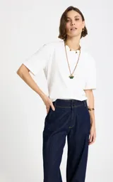 Remera blanca Le Lis Blanc confeccionada en punto de algodón, de corte recto y holgado, con escote redondo, mangas cortas amplias y detalle de abertura en la espalda.