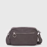 Bolso tipo bandolera de lona en color gris oscuro, con diseño compacto y cierre superior. Presenta un logo circular grabado en el frente y correa ajustable con el nombre de la marca.