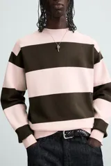 Jersey de punto con diseño de rayas horizontales anchas en color rosa claro y marrón oscuro. Presenta cuello redondo, manga larga y terminaciones en rib.
