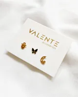 Set de tres pares de aros pequeños dorados con diferentes dijes: mano de Fátima, mariposa negra y luna con estrella.