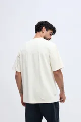 Remera de manga corta color verde militar con textura sutil y pequeña estampa discreta en el pecho.