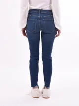 Pantalón de jean skinny azul con roturas en las rodillas y ruedo desflecado.