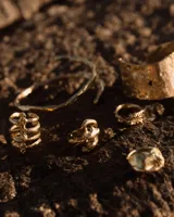 Anillo de diseño orgánico con forma irregular que evoca texturas marinas, con estructura abierta y acabado brillante.