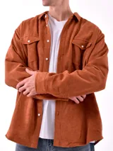 Sobrecamisa de hombre color azul marino, confeccionada en tejido de pana con textura acanalada. Presenta cuello camisero, cierre frontal con botones blancos y dos bolsillos de parche con solapa en el pecho.